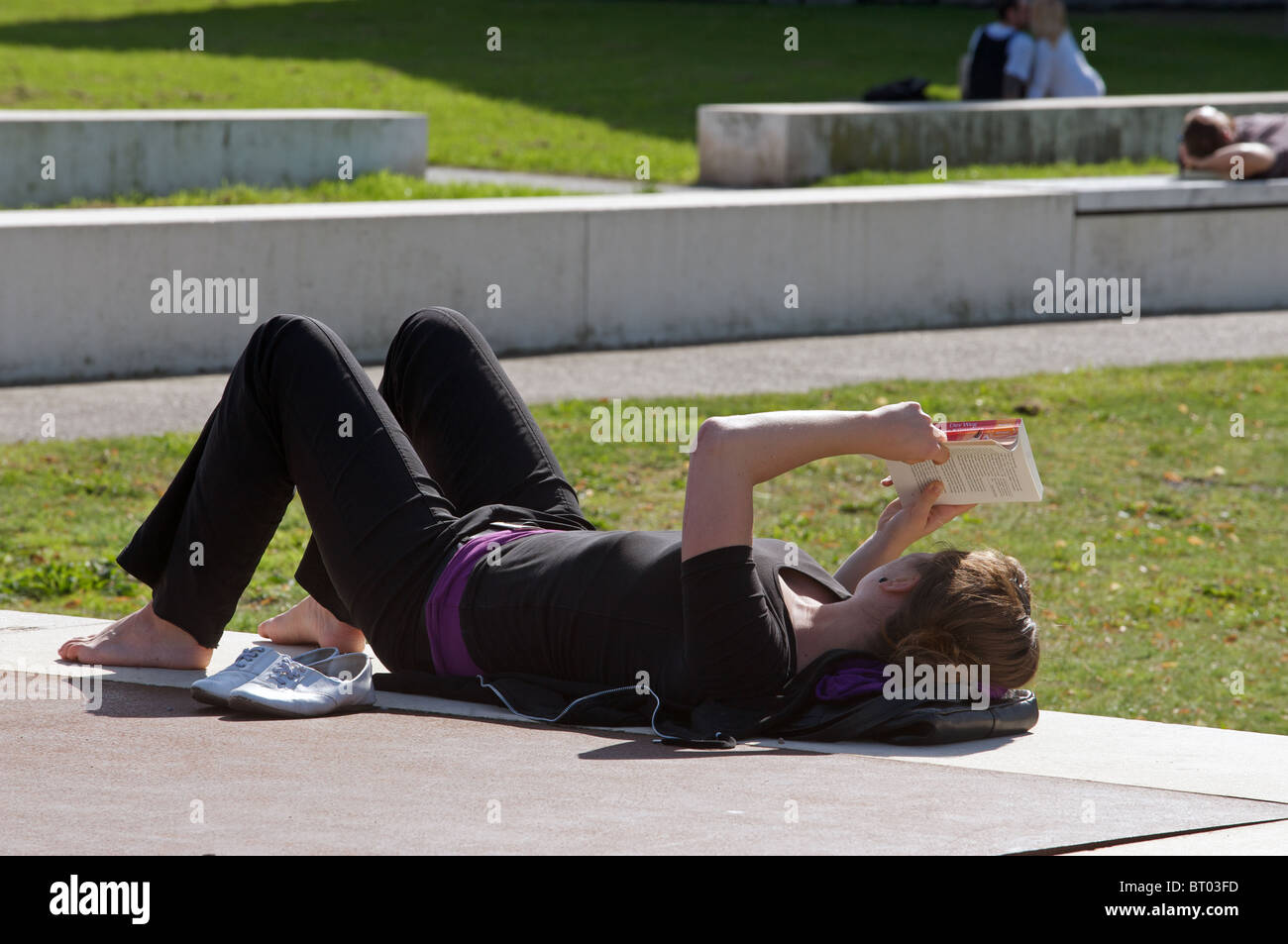 Woman relaxing outdoors while reading a book Stock Photo - Alamy