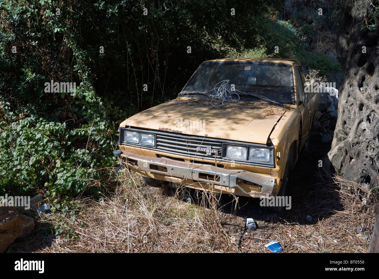 Rusting old1970s Datsun car abandoned in field in Lakones village, Paleokastritsa, Corfu Island, Greece, Europe Stock Photo