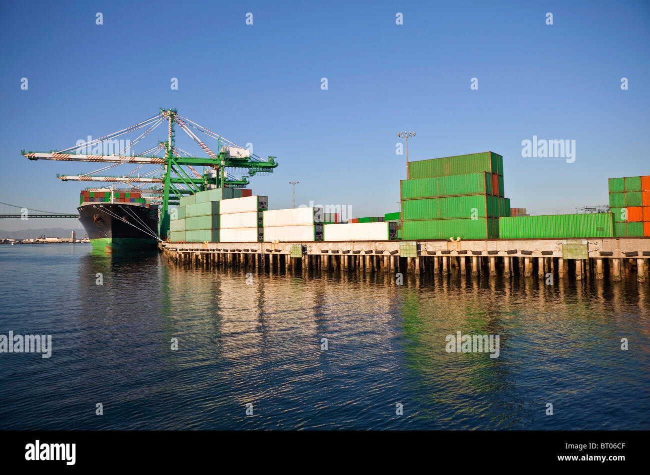 Containers, cranes and ship in warm afternoon light. Stock Photo
