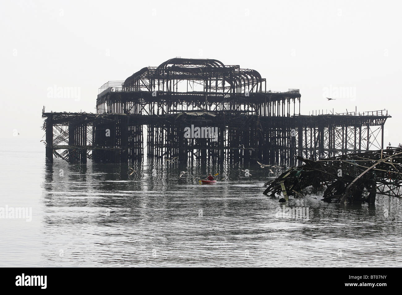 A canoeist paddles through the rusty remains of Brighton's West Pier. Picture by James Boardman Stock Photo