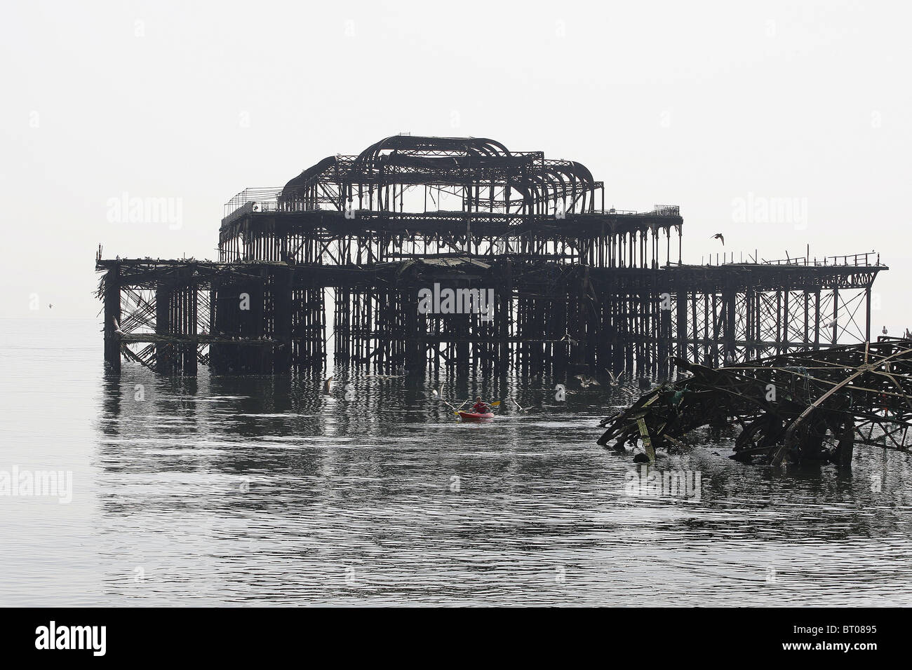 A canoeist paddles through the rusty remains of Brighton's West Pier. Picture by James Boardman Stock Photo