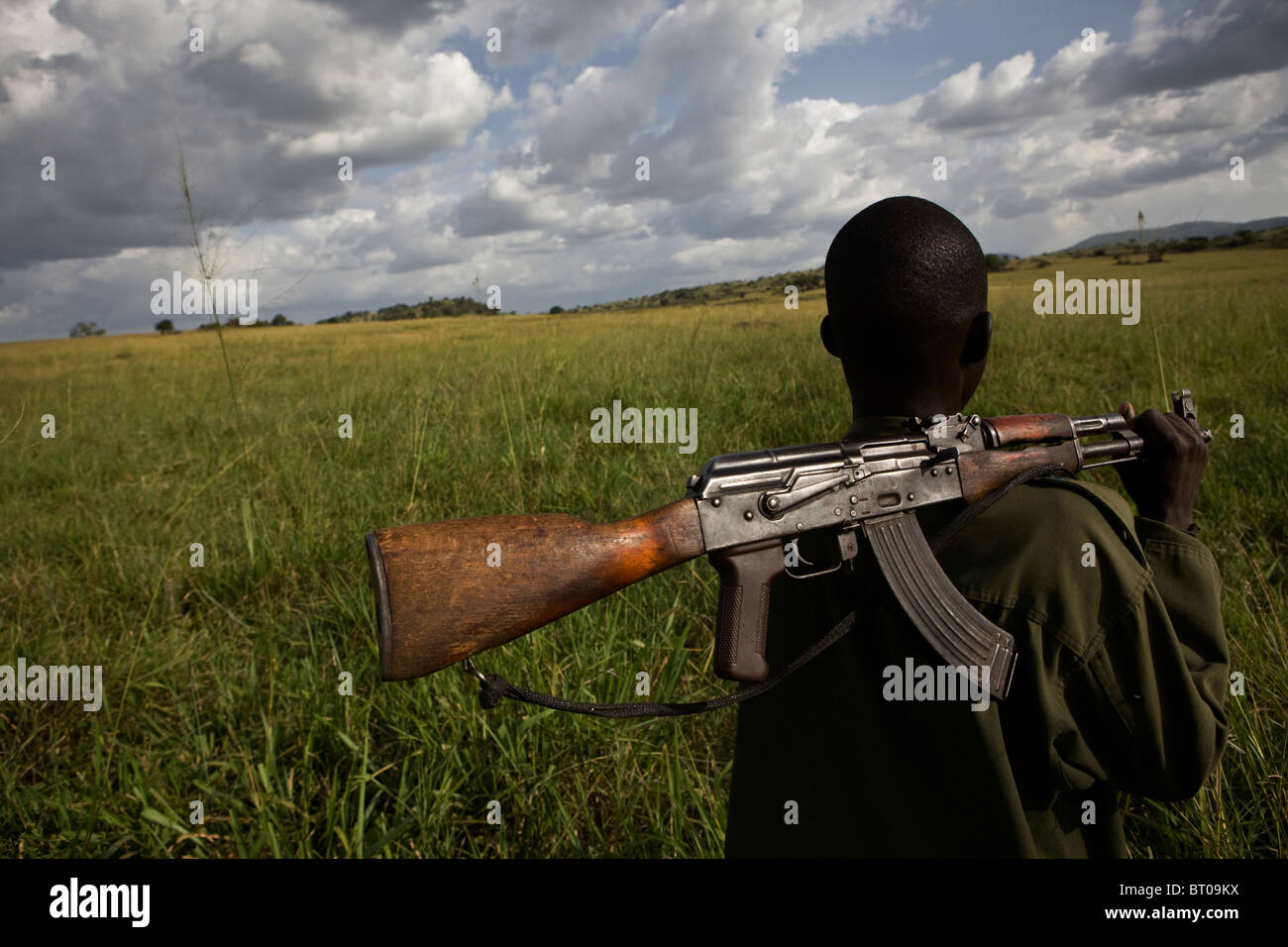 An armed ranger in northern Uganda's Kidepo Valley national park patrols along the Sudan-Uganda border. Stock Photo