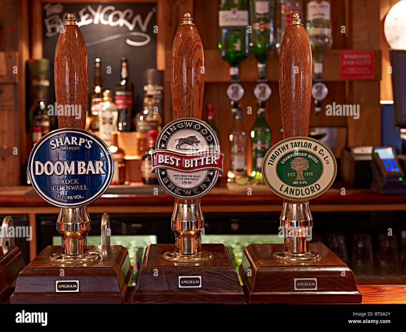 Bar pumps in an old english pub with optics on the wall Stock Photo