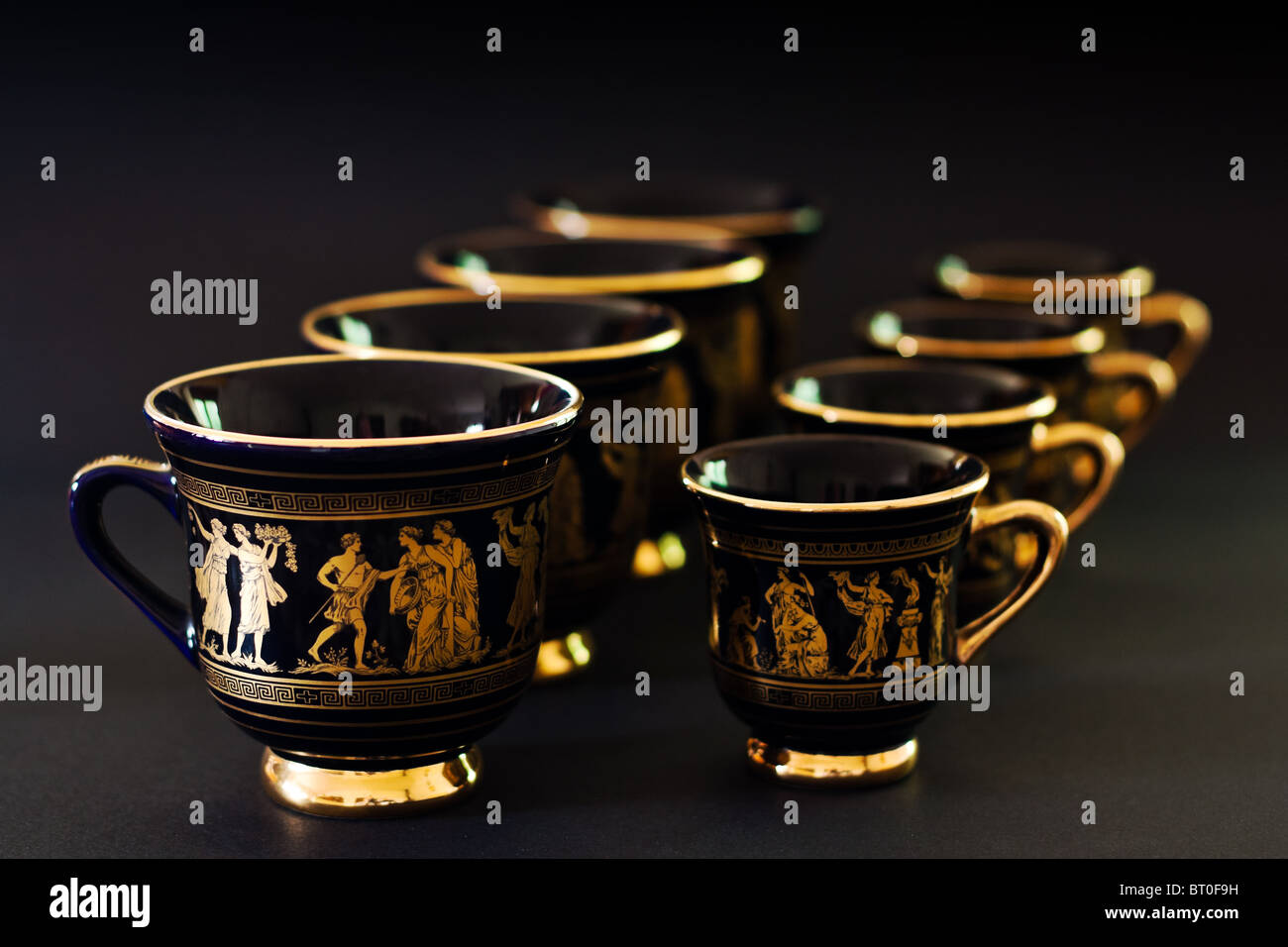 coffee cups with ancient greeks theme lined up on black background ...