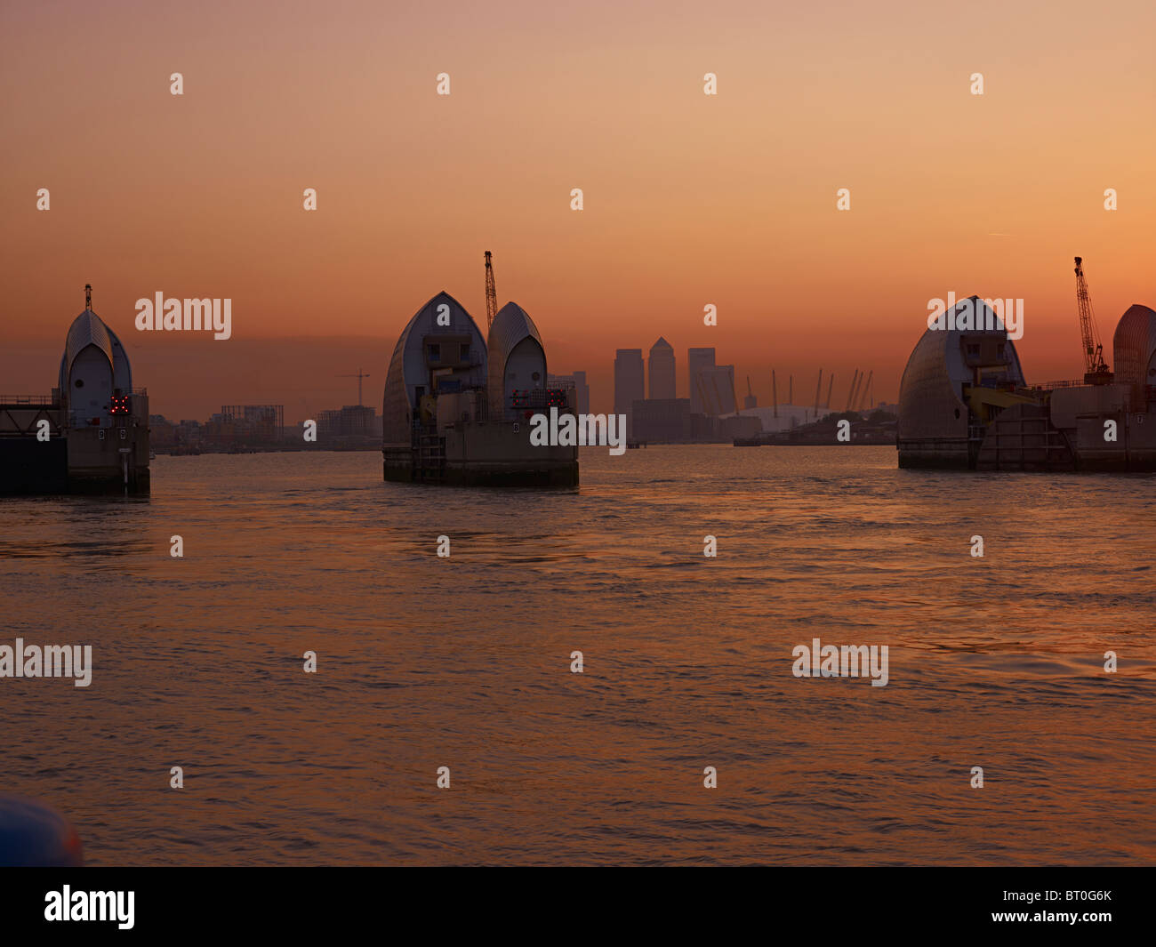 The Thames flood Barrier, a London landmark at sunset with Canary Wharf ...