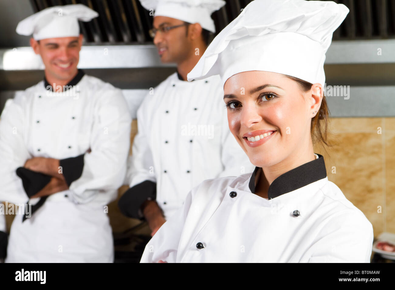 group of young beautiful professional chefs portrait in industrial kitchen Stock Photo