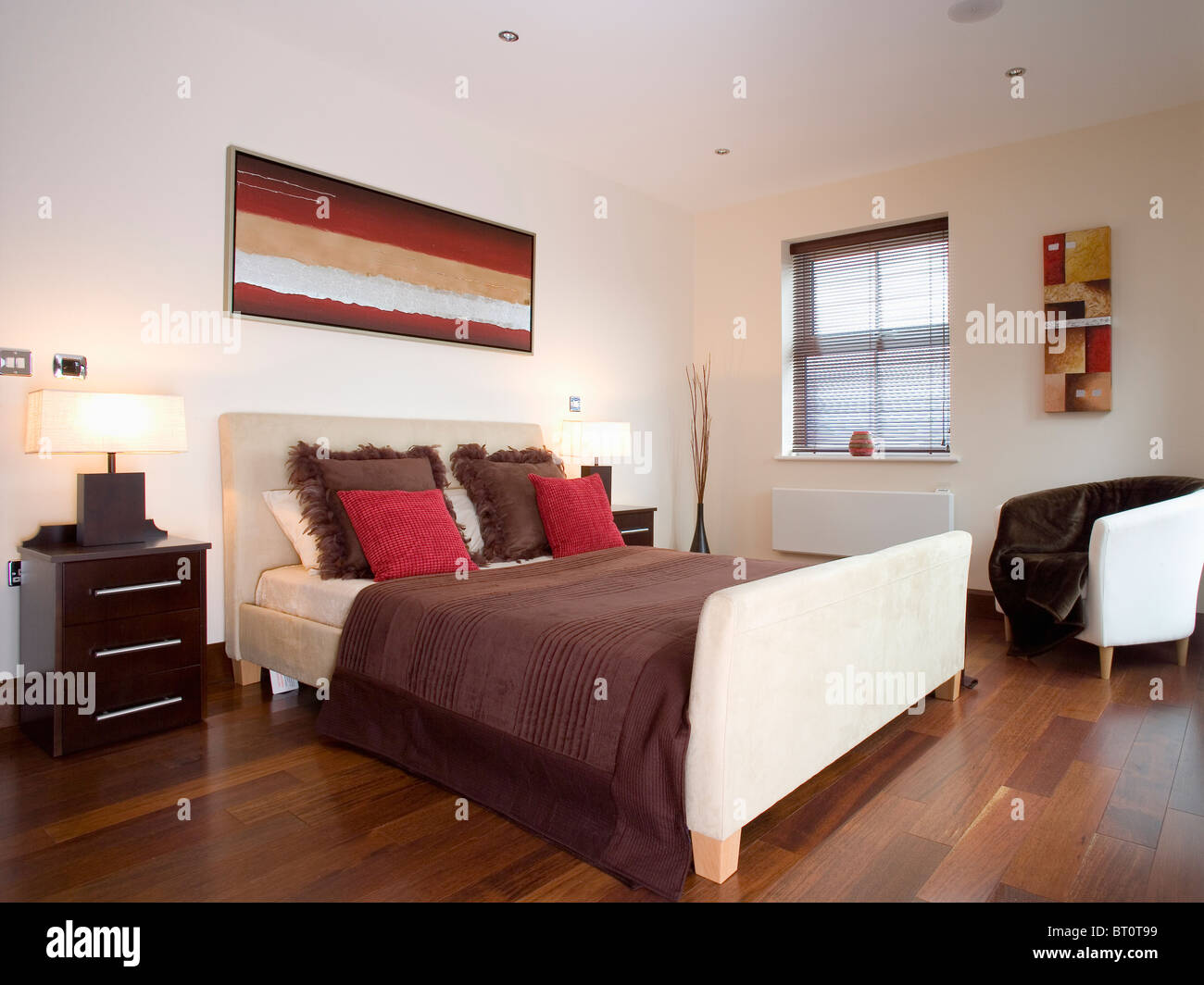Red And Brown Cushions On Beige Suede Upholstered Bed In