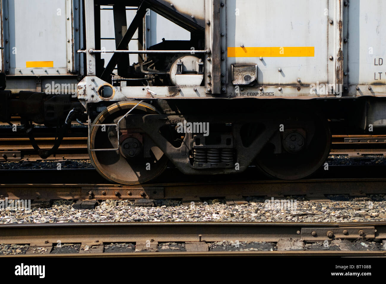 A closeup view of a set of train wheels on a coal car on railroad