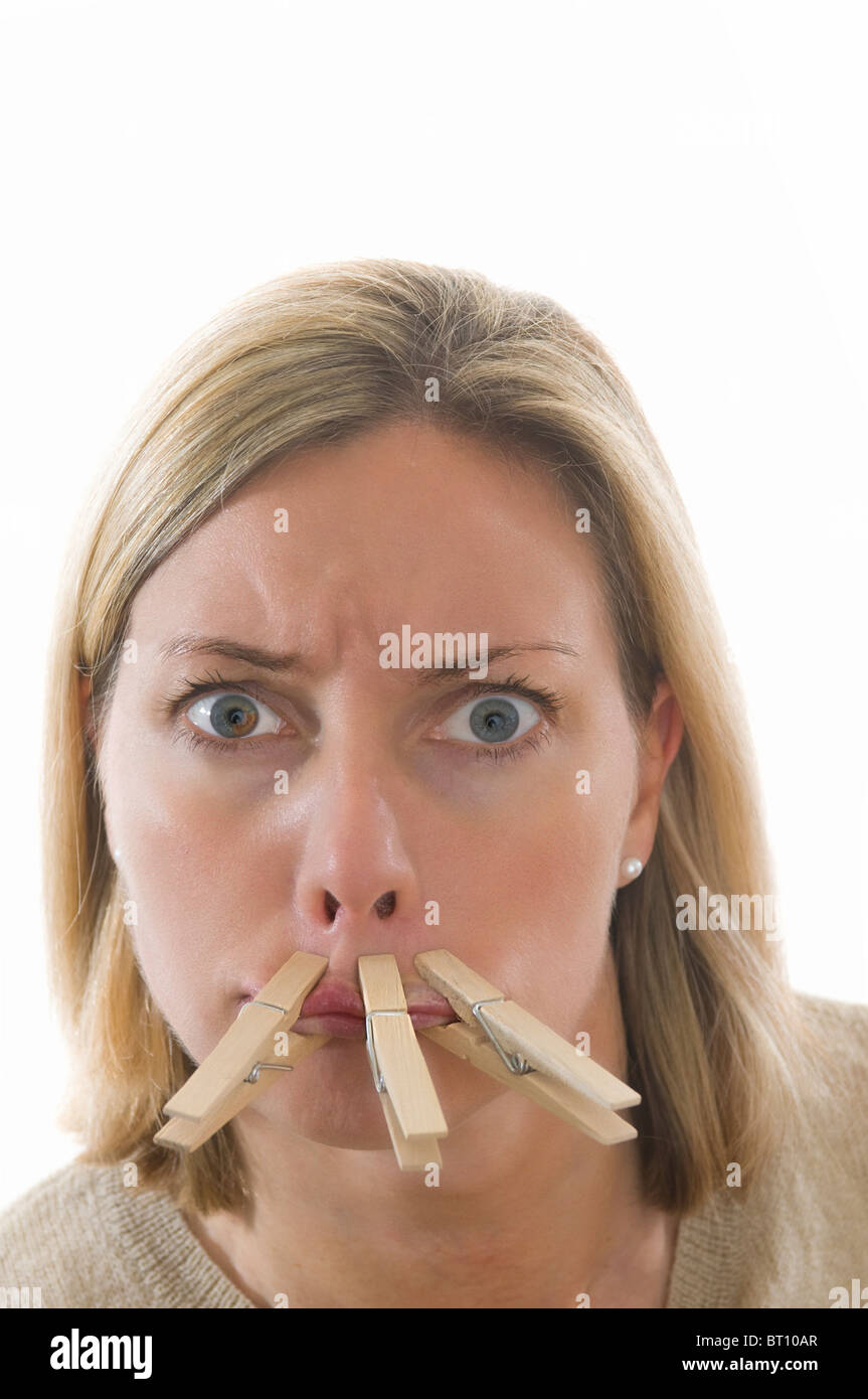 Woman with mouth pegged closed shut Stock Photo