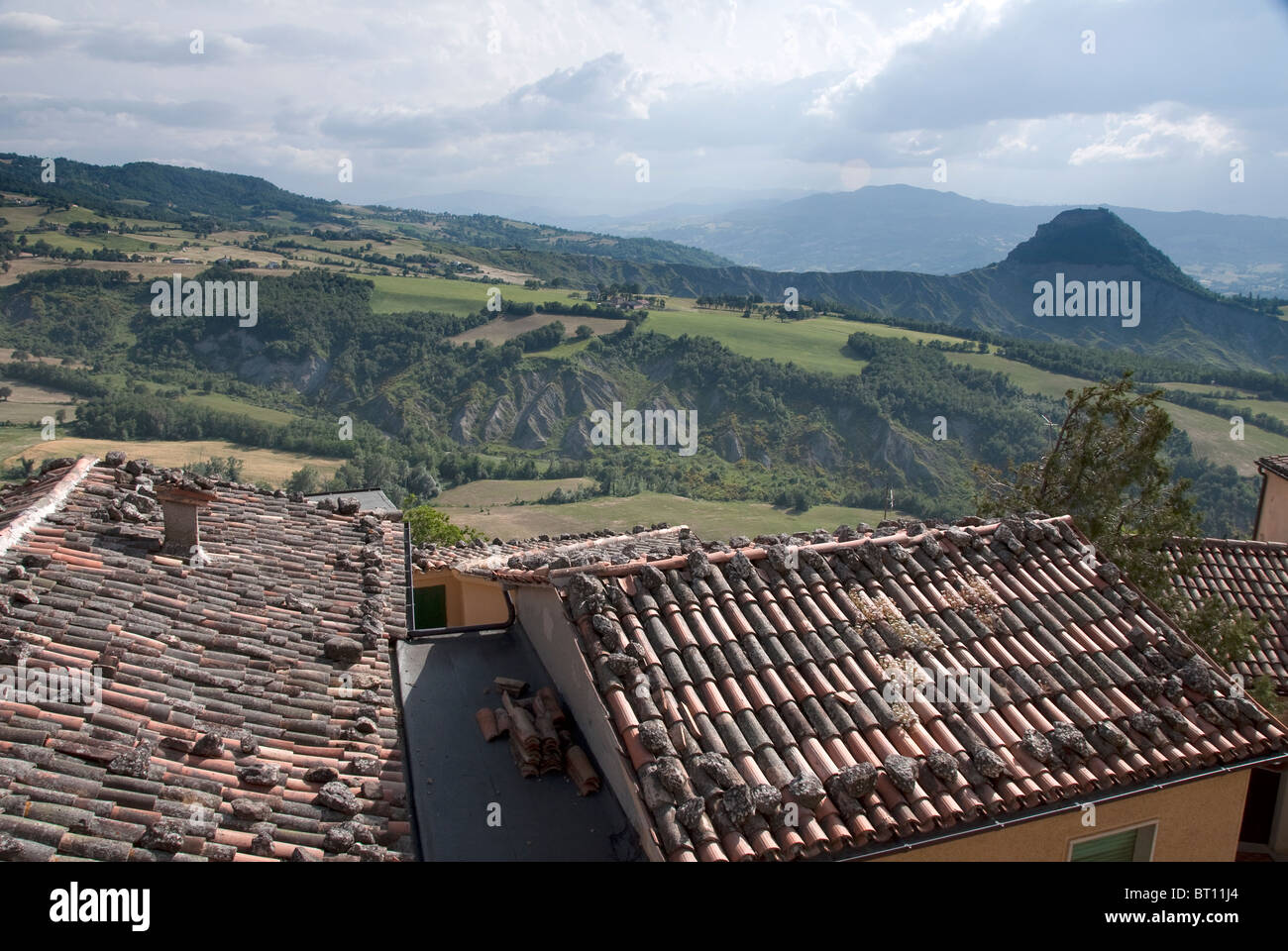 Panorama across the roofs of houses in the fortress town of San Leo, to the Appenine mountains of Le Marche. Stock Photo