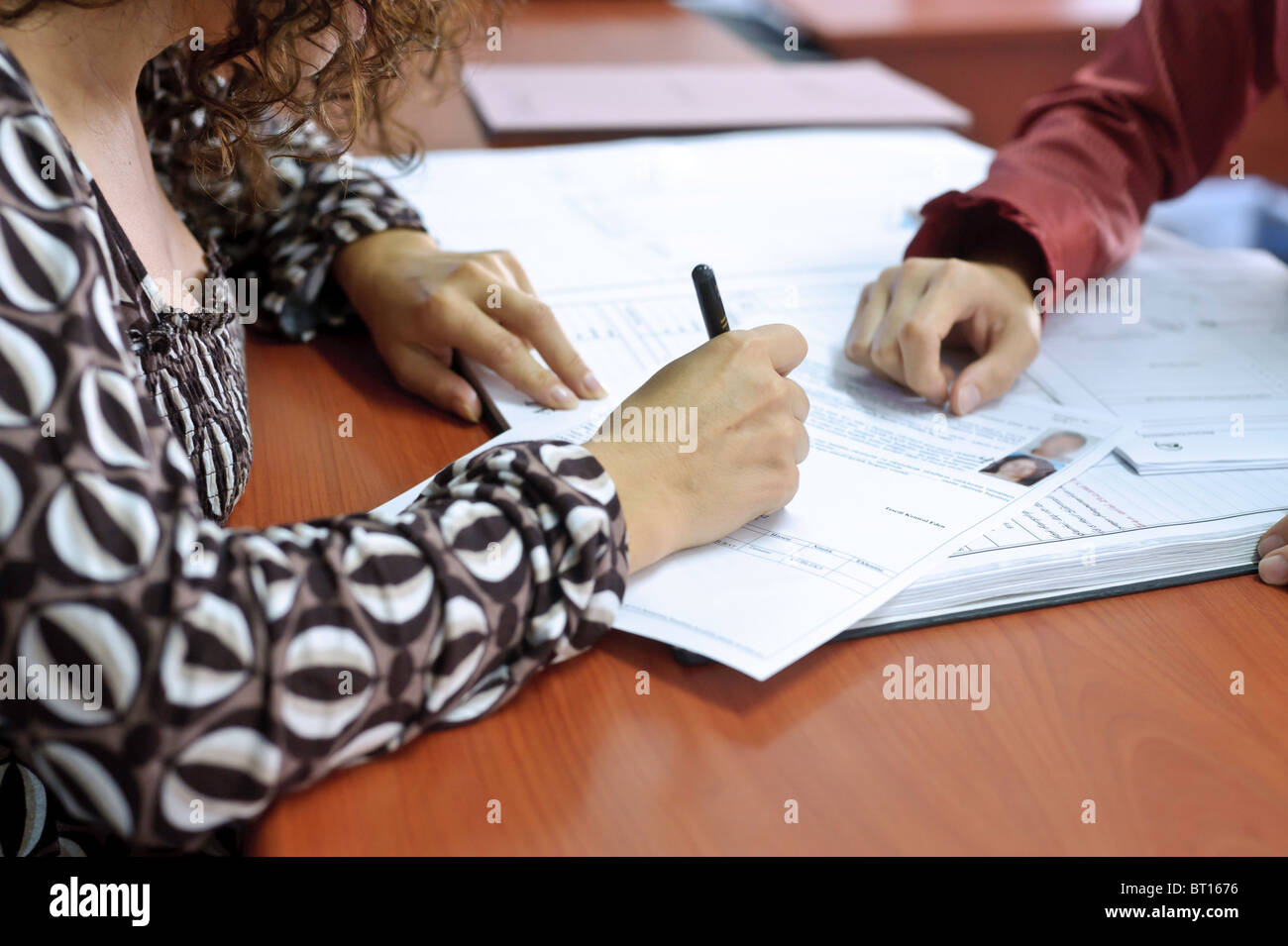 A woman signs a land registry document in Turkey. Stock Photo