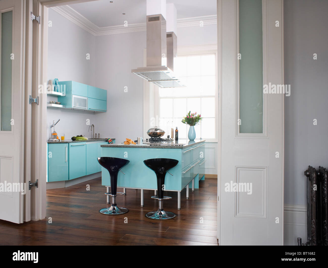Folding Double Doors Pulled Back To Show Black Stools At