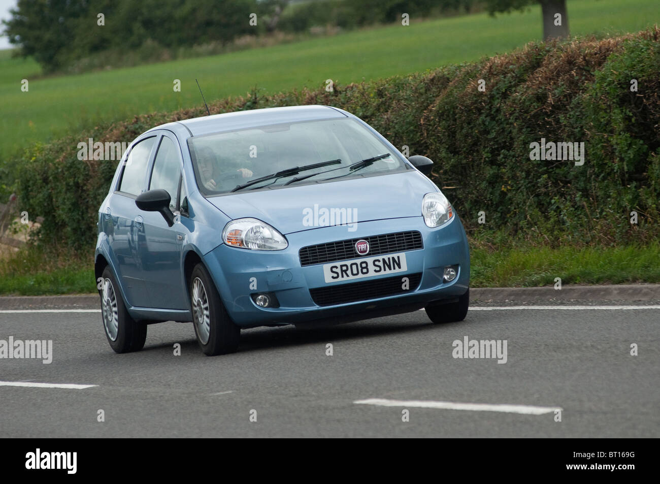 Fiat Punto car travelling along a road in the English countryside. Stock Photo