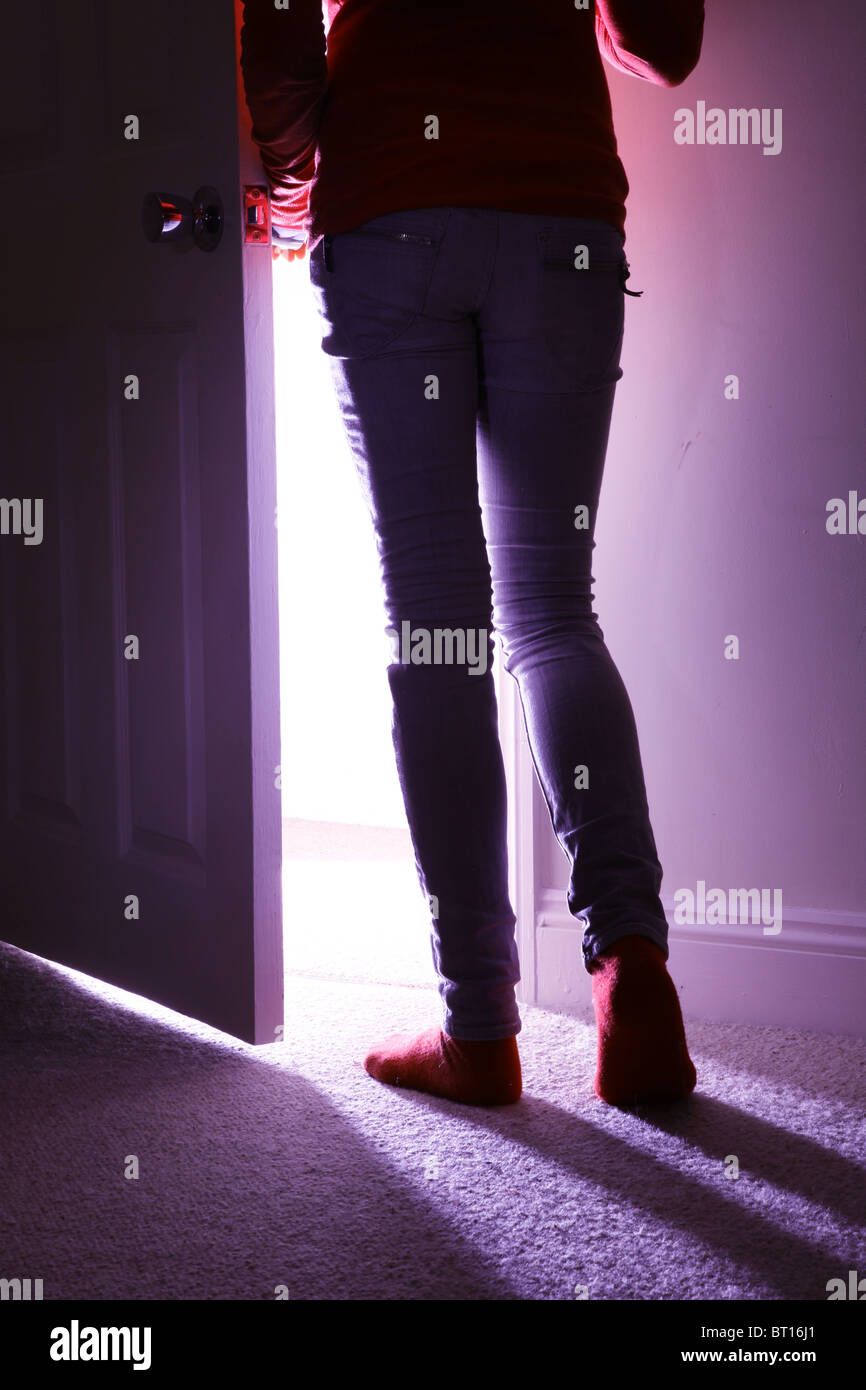 Back view of a young girl leaving a room, waist down Stock Photo