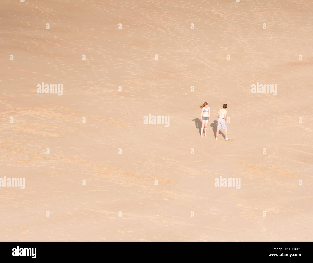 A young couple on a sandy beach in Tynemouth, UK Stock Photo