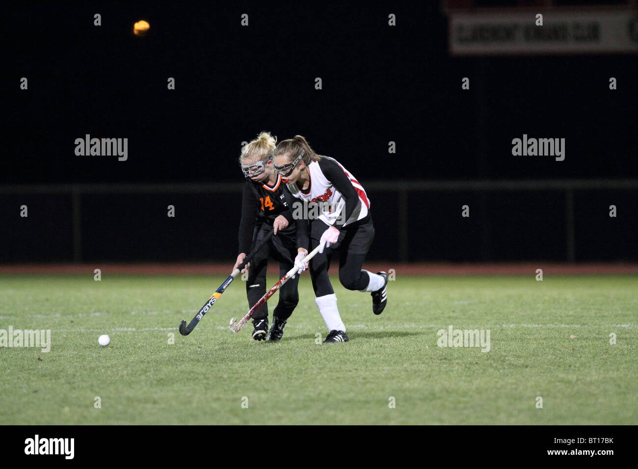 Two high school girls play field hockey Stock Photo