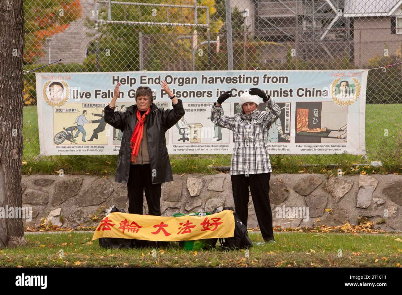 Falun Gong members practice an exercise by a major Ottawa artery in front of a protest sign Stock Photo
