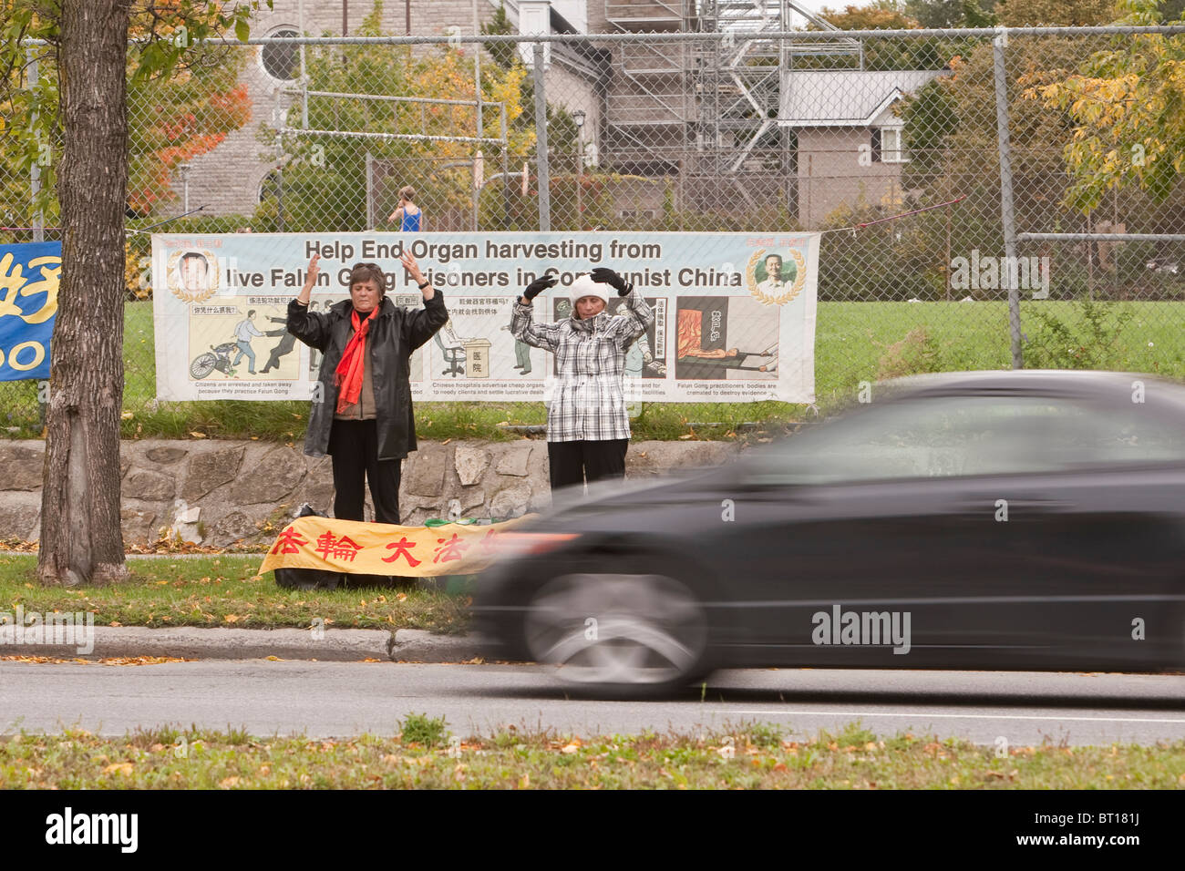 Falun Gong members practice an exercise by a major Ottawa artery in front of a protest sign Stock Photo