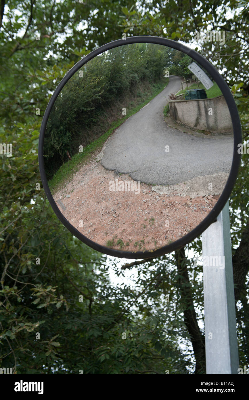 Round mirror to help drivers see round corners with the road and ...