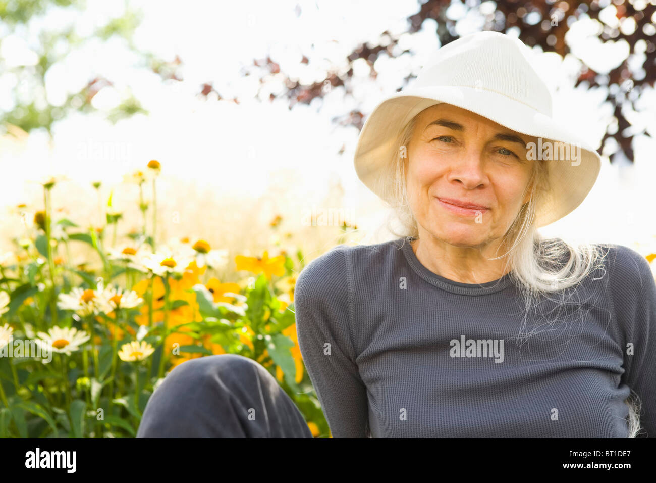 Smiling Caucasian woman sitting in garden Stock Photo - Alamy