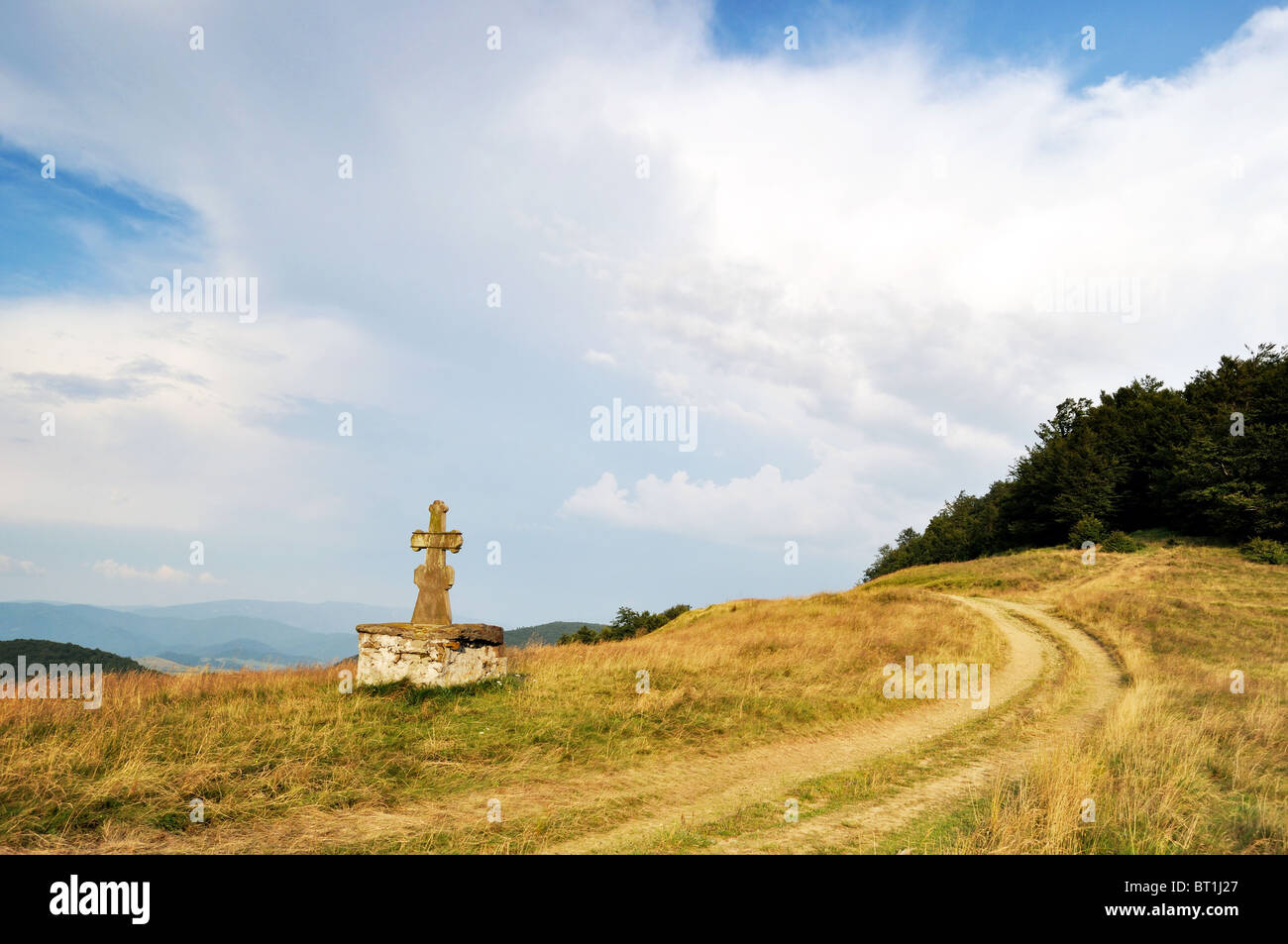 Stone cross and lost roads Stock Photo