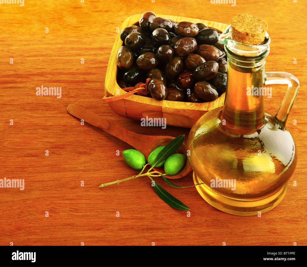 Olive Oil with fresh green & marinated black olives over wood background Stock Photo