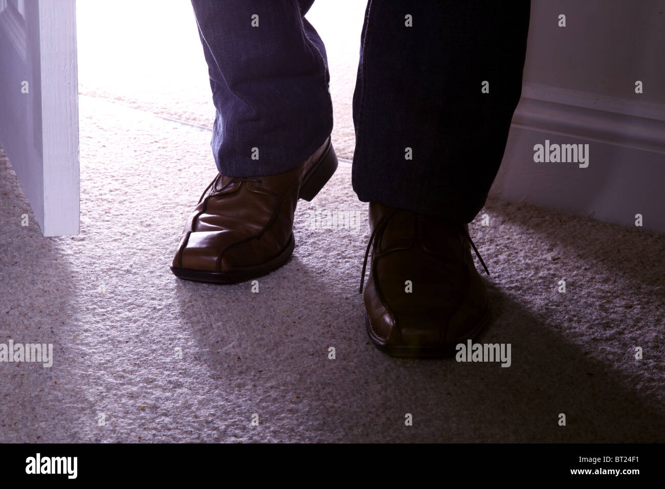 Brown man's shoes walking into a room Stock Photo