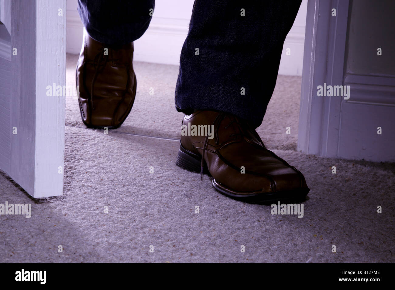 Close up of a man's feet entering a doorway Stock Photo
