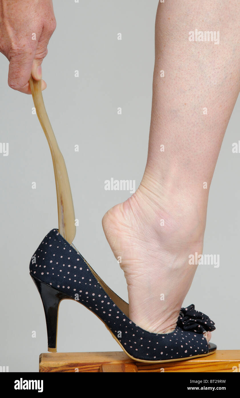 Woman using a shoehorn to get into her high heel shoe Stock Photo Alamy