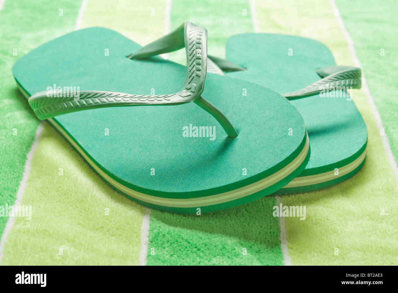 Green flip flop sandals on beach towel Stock Photo Alamy