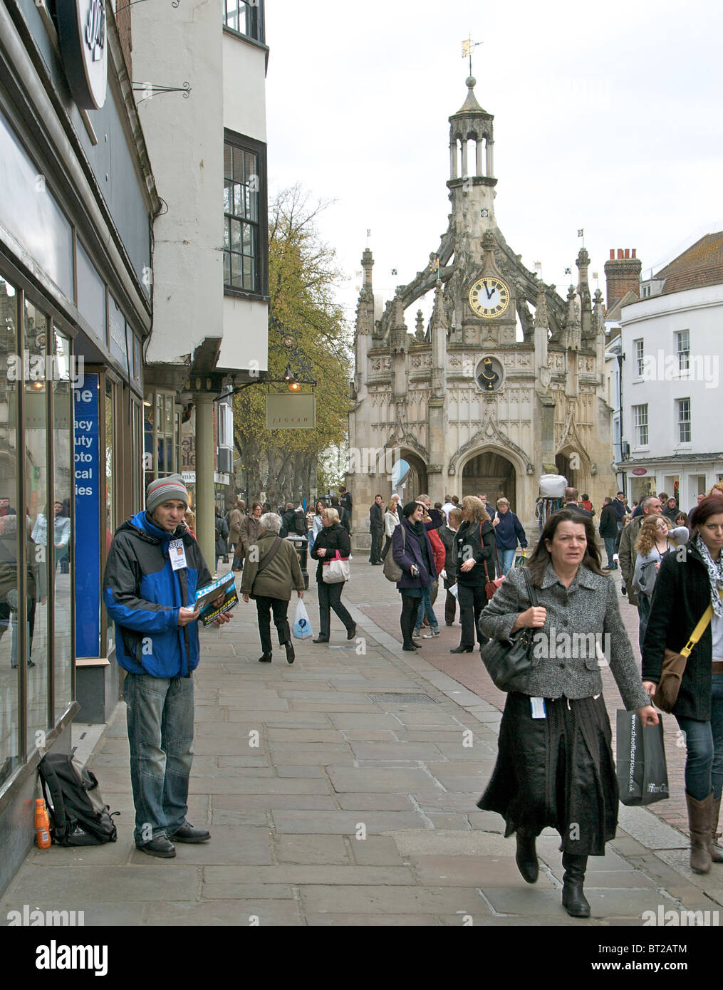 A 'Big Issue' seller in East Street, Chichester, Sussex with shoppers - EDITORIAL USE ONLY Stock Photo