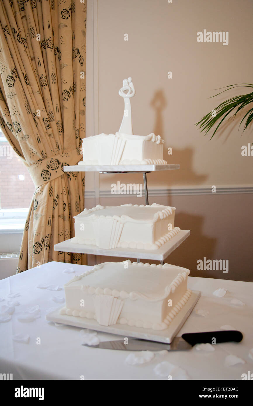 A three tiered wedding cake on display at a wedding reception. The cake is styled in the 1930's Art Deco style. Stock Photo