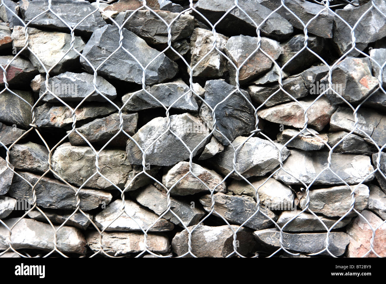 View of many stones behind wire netting Stock Photo