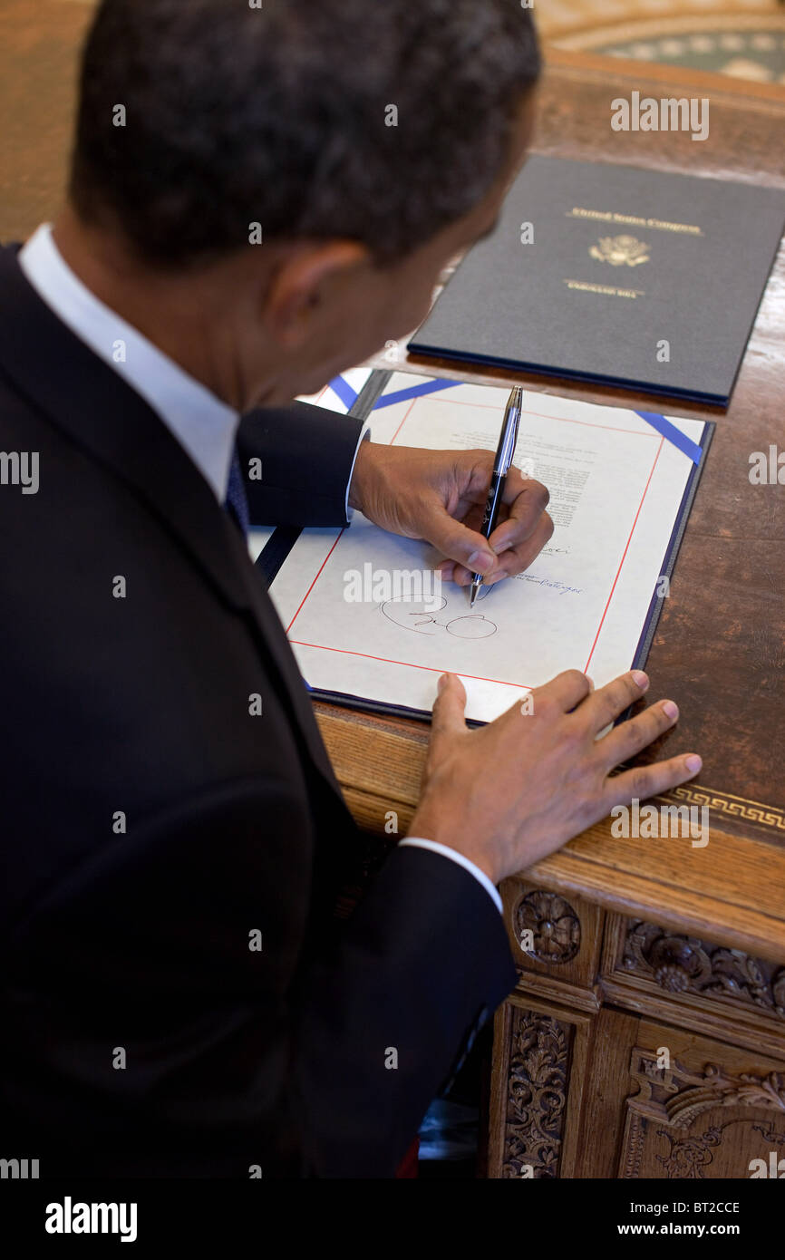 President Barack Obama signs H.R. 2097, the Star-Spangled Banner Commemorative Coin Act, at the Resolute Desk in the Oval Office Stock Photo