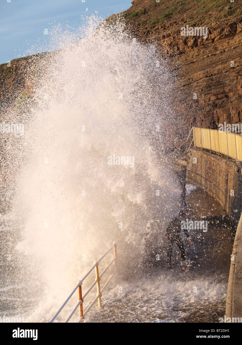 Large wave hitting wall and going over railings, Cornwall, UK Stock Photo