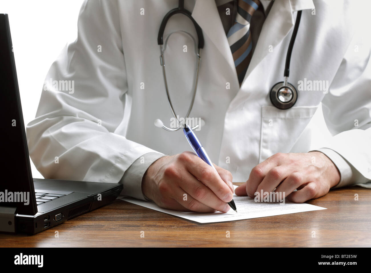 Doctor writing a prescription or medical examination notes Stock Photo