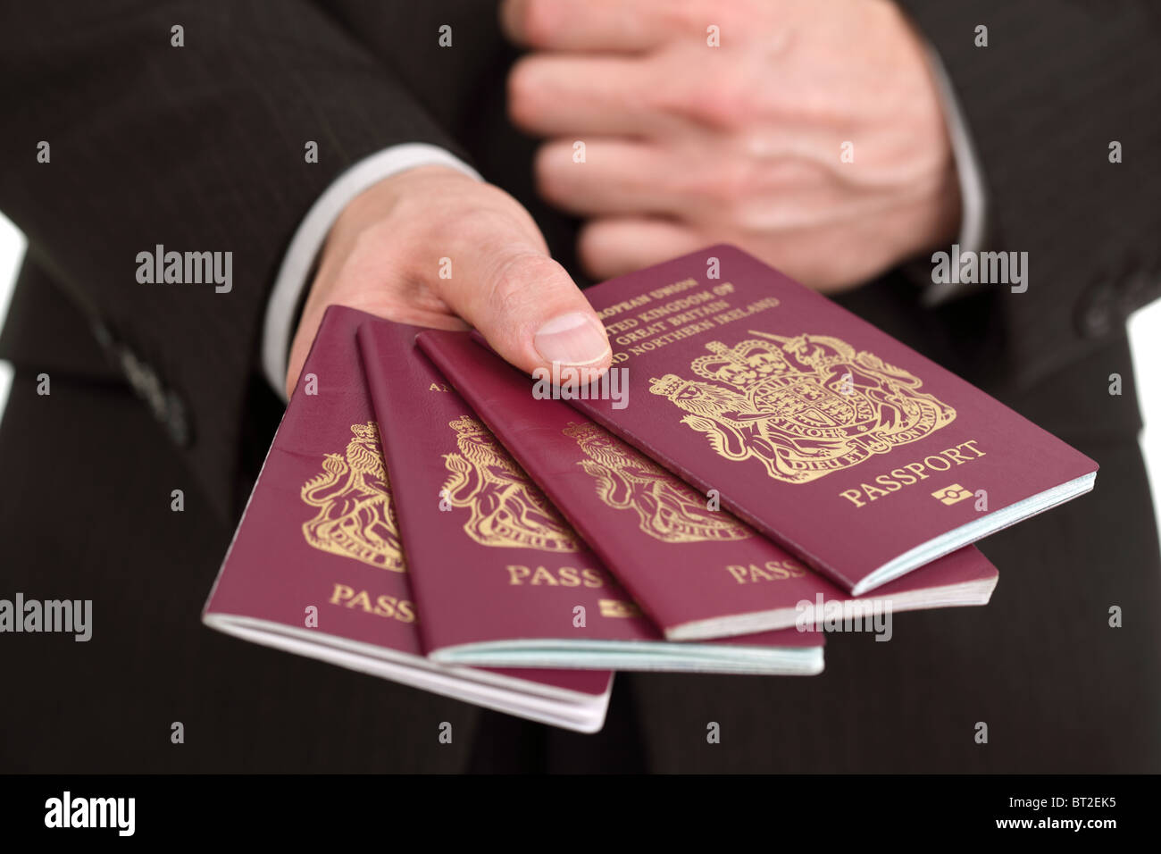 Presenting four British passports at the airport Stock Photo