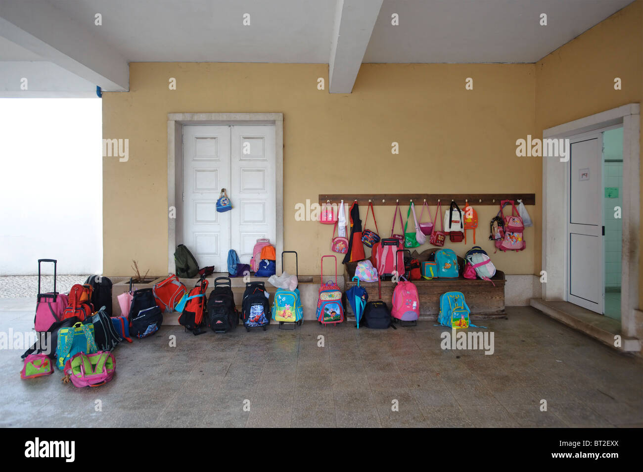 Kids Bags And Backpacks Hanging On Hooks And Lying On The Floor