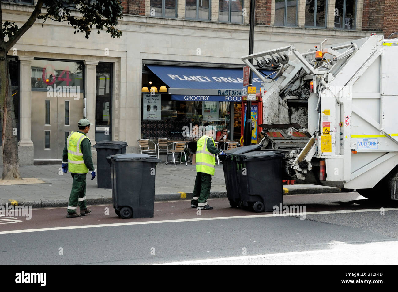Rubbish collection, bin men working at the back of a lorry, London England  UK Stock Photo - Alamy