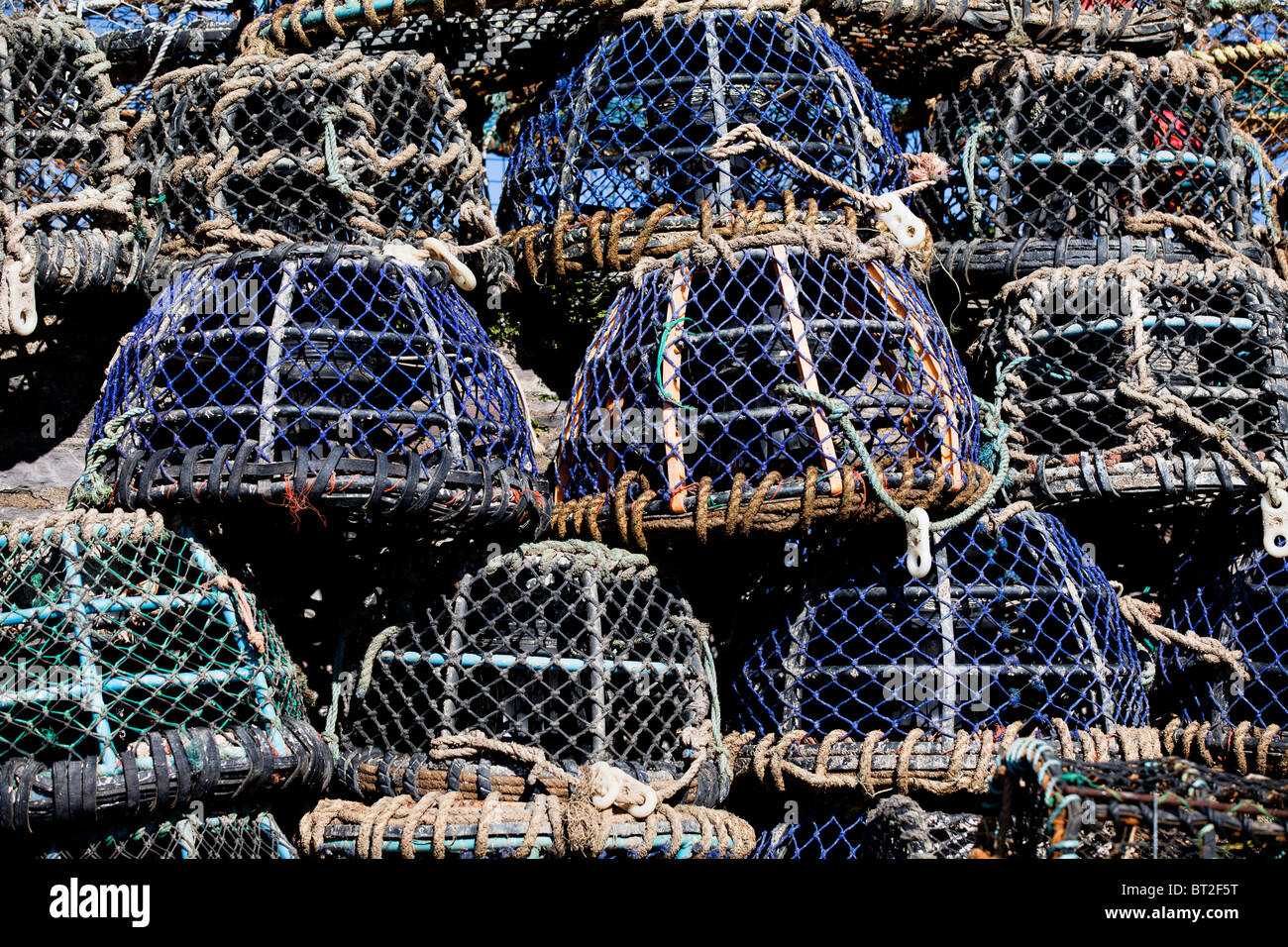 stacked lobster and crab pots on the harbourside in the fishing port of Brixham, Devon, UK Stock Photo
