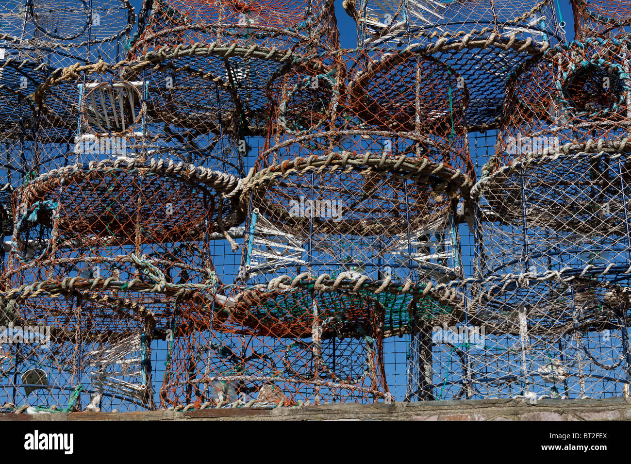 stacked lobster and crab pots on the harbourside in the fishing port of Brixham, Devon, UK Stock Photo
