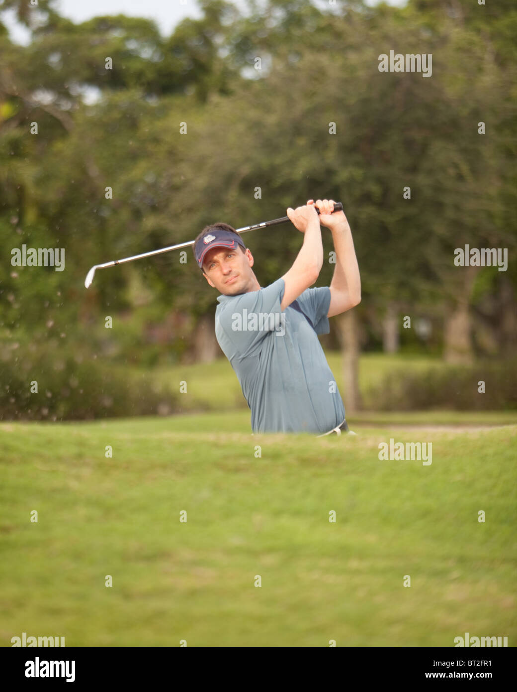 Golfer coming out of a sand trap. Stock Photo
