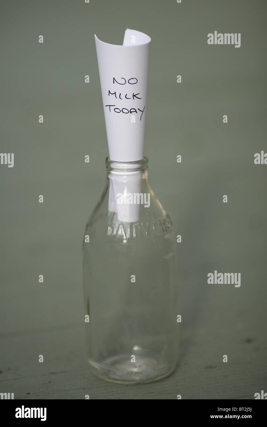 A milk bottle with a note in it reading 'No milk today'. Stock Photo