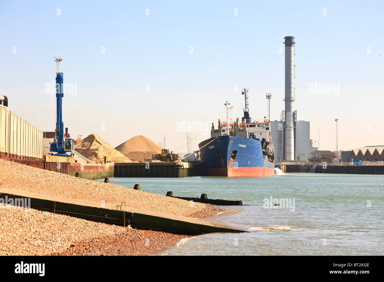 The beach at Shoreham Harbour entrance and power station in the port Stock Photo