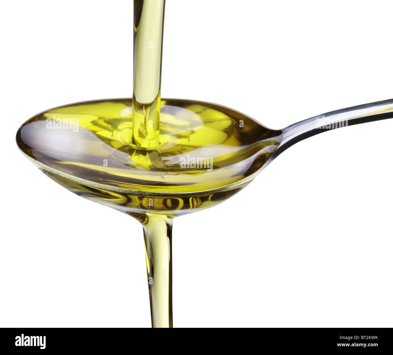 Olive oil flowing into the spoon isolated on a white. Stock Photo