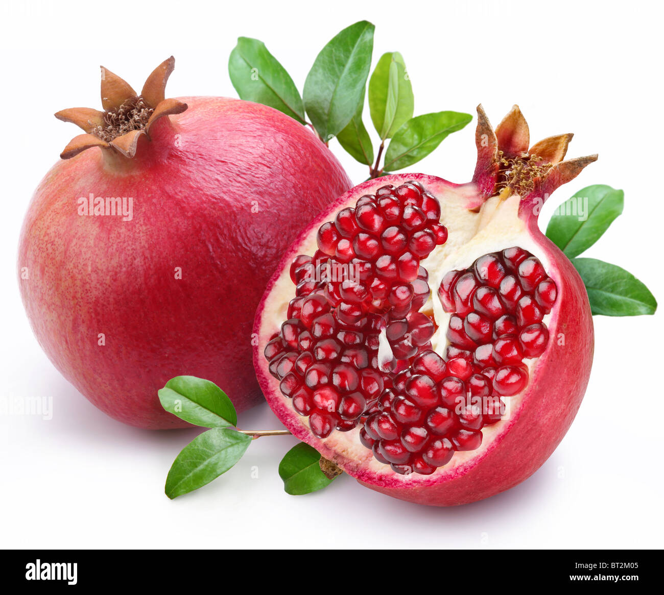 Juicy pomegranate and its half with leaves. Isolated on a white background. Stock Photo