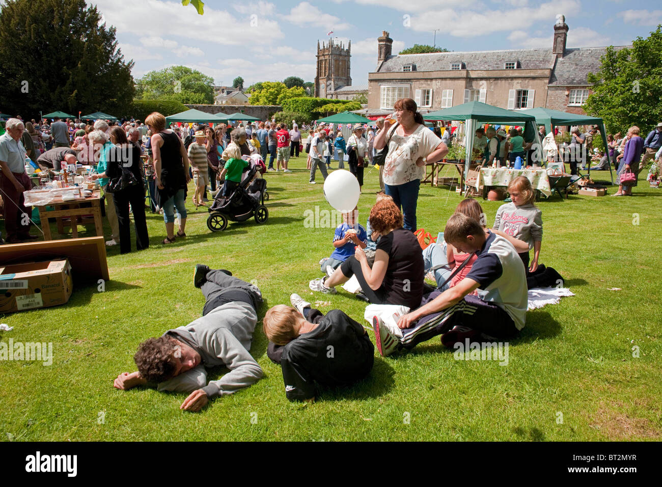 A family sits on the grass at the annual summer Charminster Fete, in