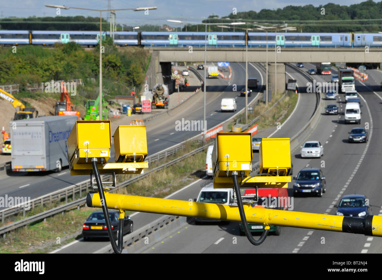Junction 28 M25 motorway road widening site construction transport project variable speed camera train on railway bridge Brentwood Essex England UK Stock Photo