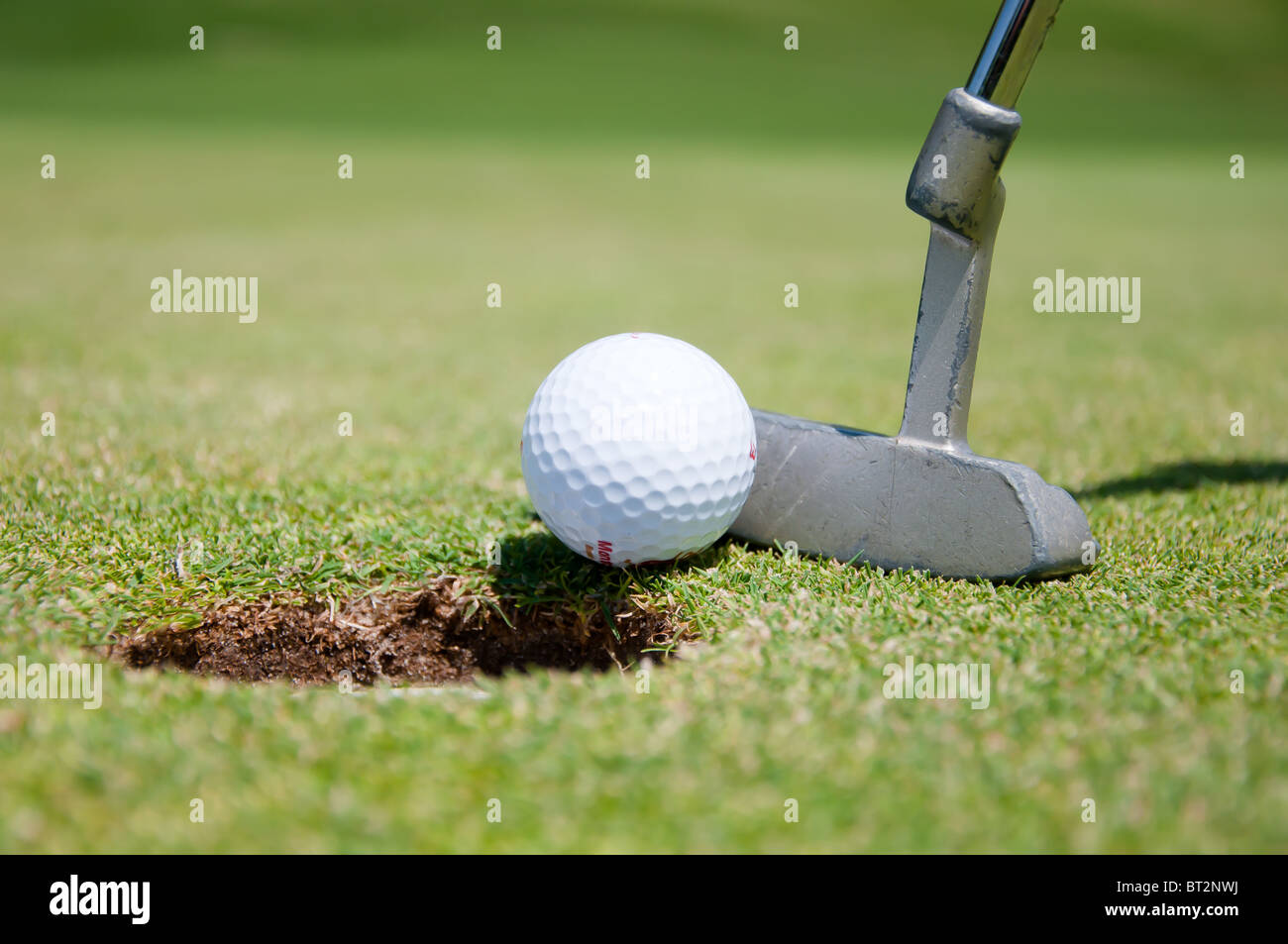 golf hole with ball and putt Stock Photo