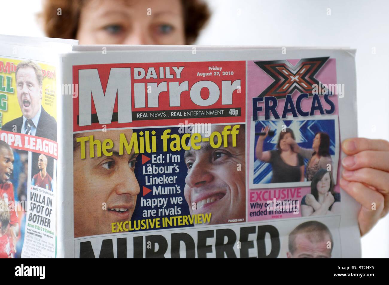 Woman reading a copy of The Daily Mirror newspaper Stock Photo - Alamy